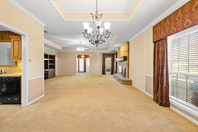 unfurnished living room with ceiling fan with notable chandelier, a raised ceiling, light carpet, and a brick fireplace