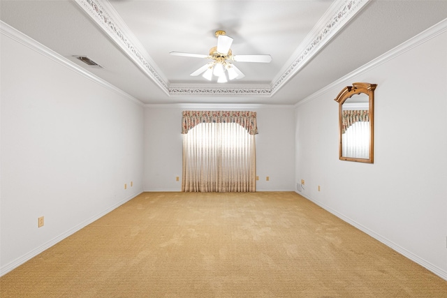 carpeted empty room featuring a tray ceiling, crown molding, plenty of natural light, and ceiling fan