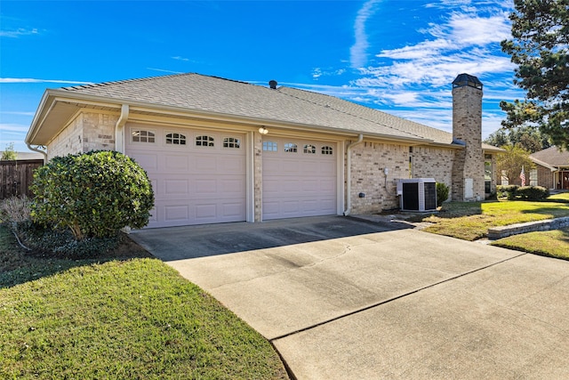 view of front facade featuring a front lawn, a garage, and cooling unit