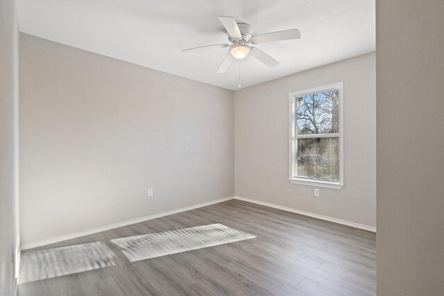 spare room with ceiling fan and dark wood-type flooring