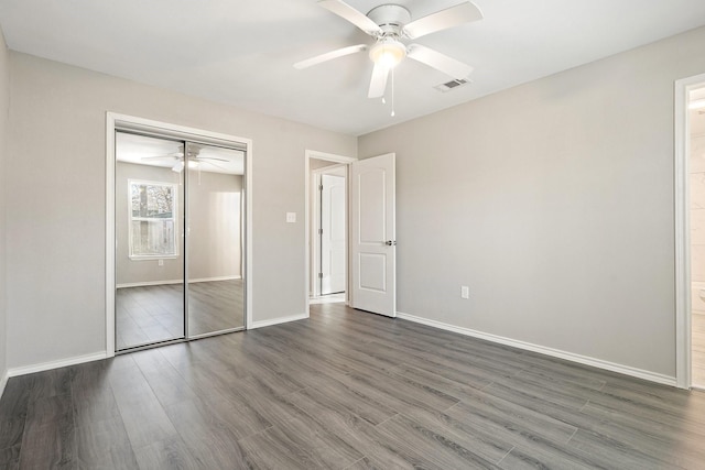 unfurnished bedroom with dark hardwood / wood-style flooring, a closet, and ceiling fan