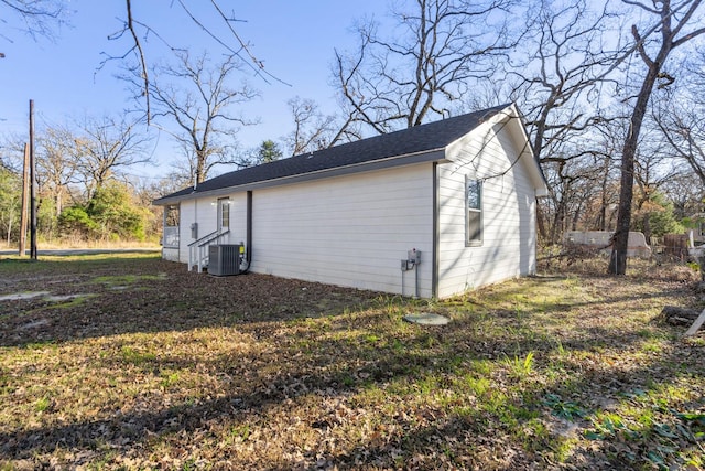 view of property exterior with central AC and a lawn