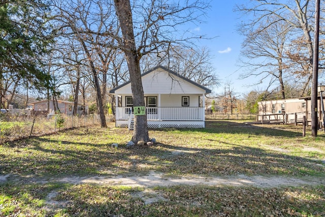 exterior space with covered porch and a front yard