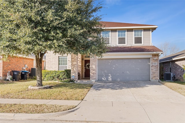 view of front of property featuring a garage, a front yard, and central AC unit