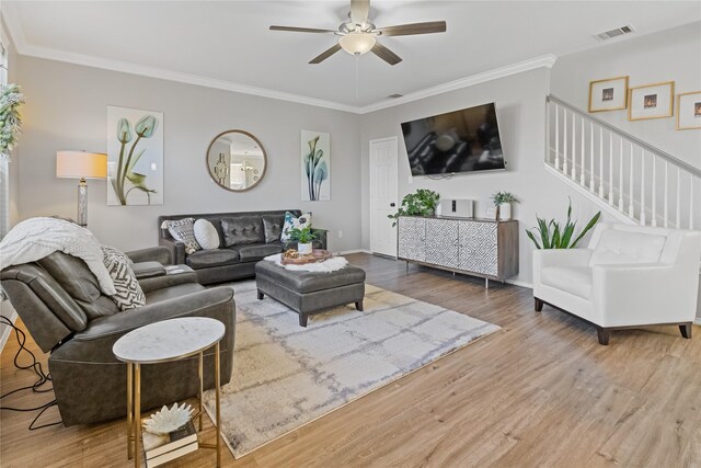 living room featuring hardwood / wood-style floors, ceiling fan, and crown molding