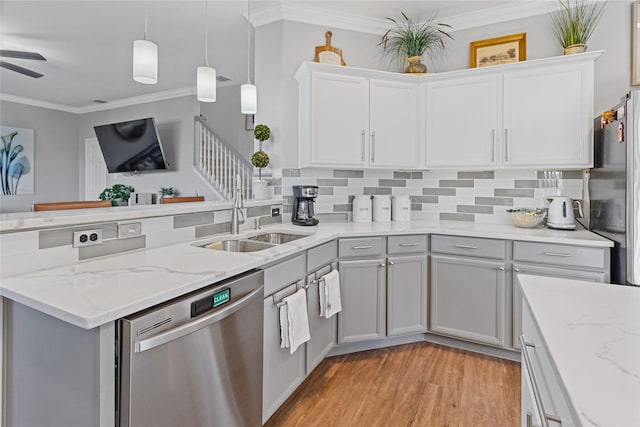 kitchen featuring tasteful backsplash, stainless steel appliances, sink, pendant lighting, and light hardwood / wood-style floors