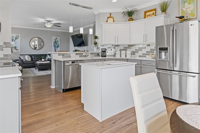 kitchen with white cabinetry, backsplash, kitchen peninsula, decorative light fixtures, and appliances with stainless steel finishes