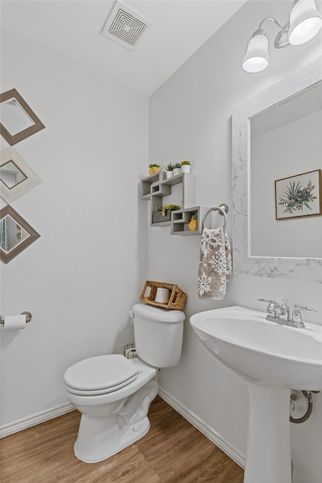 bathroom with hardwood / wood-style floors and toilet