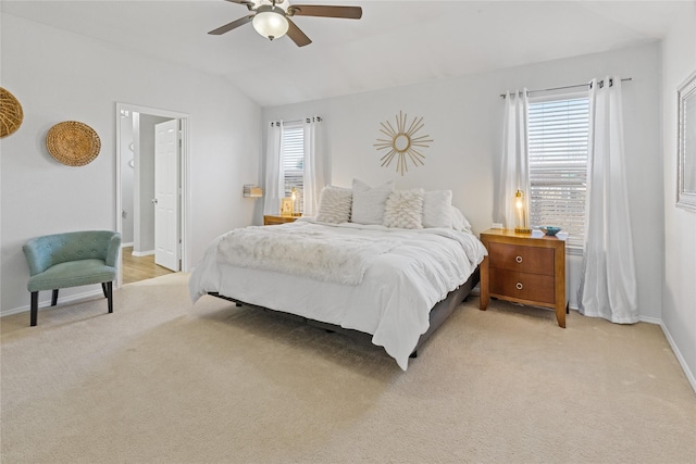 carpeted bedroom featuring multiple windows, ceiling fan, and vaulted ceiling