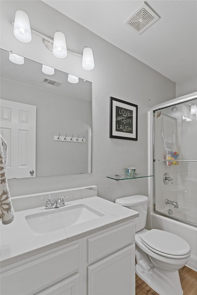 full bathroom featuring toilet, vanity, enclosed tub / shower combo, and hardwood / wood-style flooring