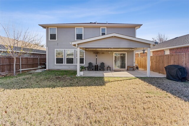 back of property with a yard and a patio