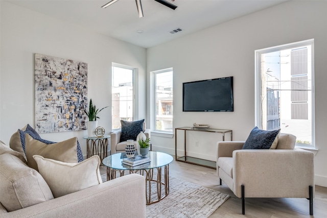 living room with ceiling fan, light hardwood / wood-style floors, and a wealth of natural light