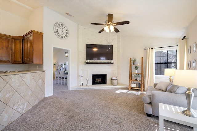 living room featuring ceiling fan, vaulted ceiling, and carpet flooring