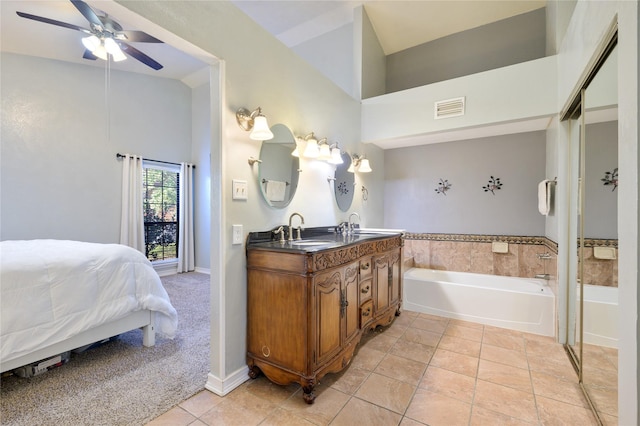 bathroom with tile patterned flooring, ceiling fan, a bathtub, and vanity