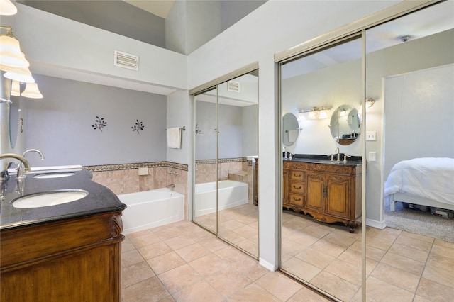 bathroom with vanity, tile patterned flooring, and a bathing tub