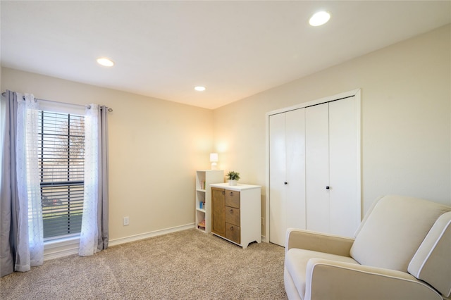 living area featuring light carpet