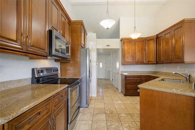 kitchen featuring light stone counters, decorative light fixtures, stainless steel appliances, light tile patterned flooring, and sink