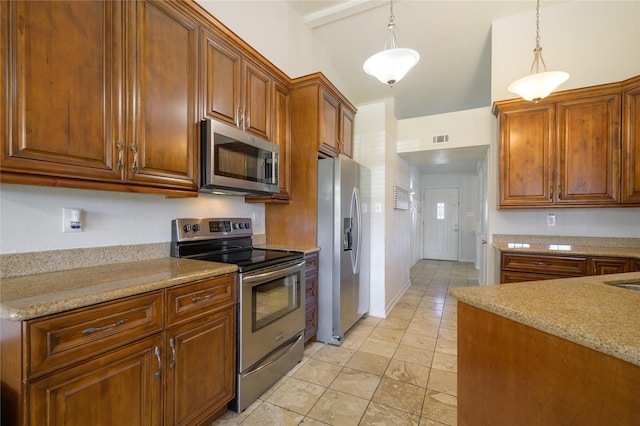 kitchen with light stone counters, appliances with stainless steel finishes, and pendant lighting