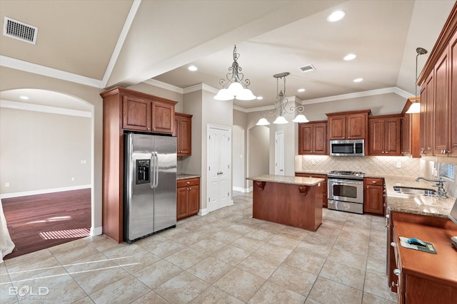 kitchen featuring sink, stainless steel appliances, a center island, light stone countertops, and vaulted ceiling