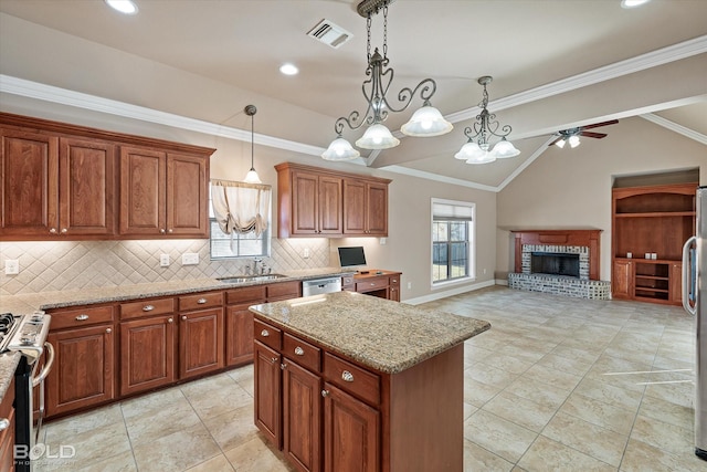 kitchen featuring a kitchen island, appliances with stainless steel finishes, pendant lighting, sink, and light stone countertops