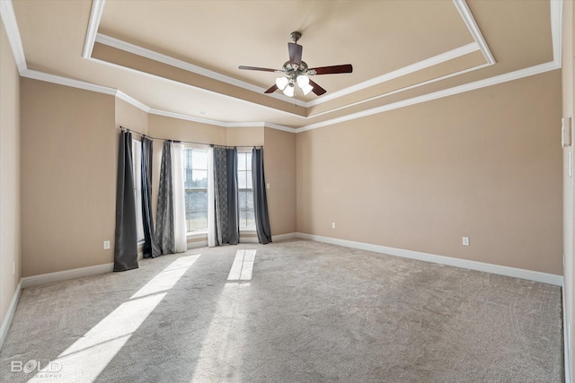 carpeted spare room featuring crown molding, ceiling fan, and a tray ceiling