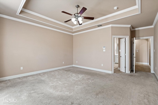 carpeted spare room with crown molding, ceiling fan, and a tray ceiling