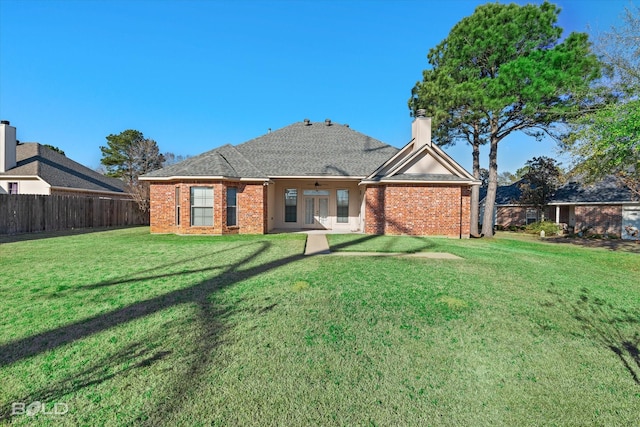 rear view of property featuring a yard