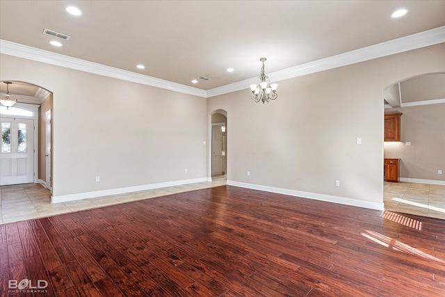 unfurnished living room featuring crown molding, a chandelier, and light wood-type flooring