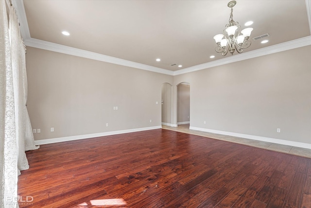 unfurnished room featuring dark wood-type flooring, crown molding, and a notable chandelier