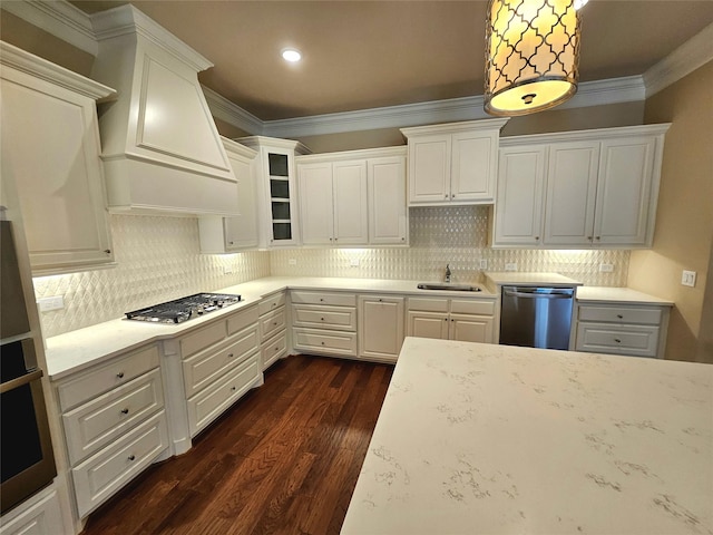 kitchen featuring white cabinetry, appliances with stainless steel finishes, ornamental molding, and decorative light fixtures