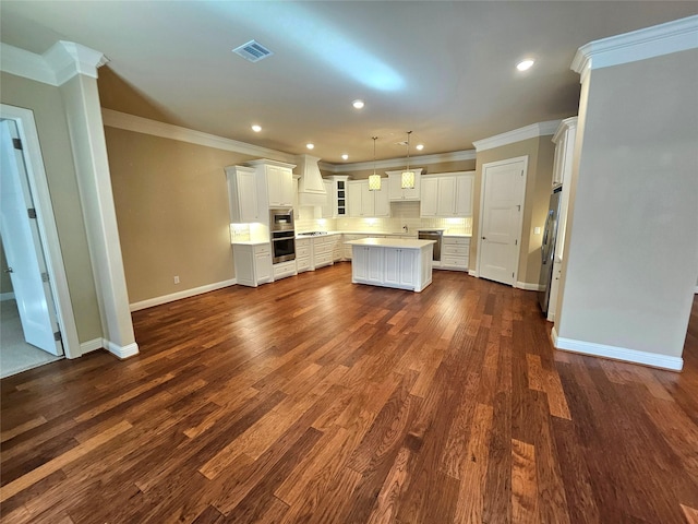 kitchen with pendant lighting, a center island, ornamental molding, white cabinets, and decorative backsplash