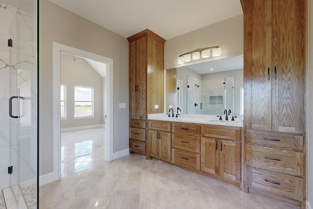 bathroom with double vanity, baseboards, a marble finish shower, and a sink