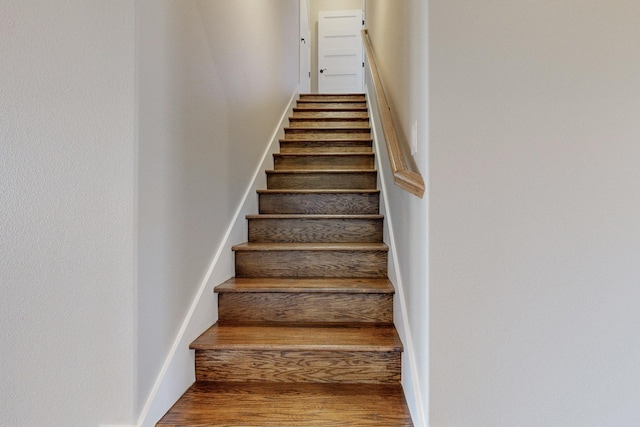 stairs featuring wood finished floors