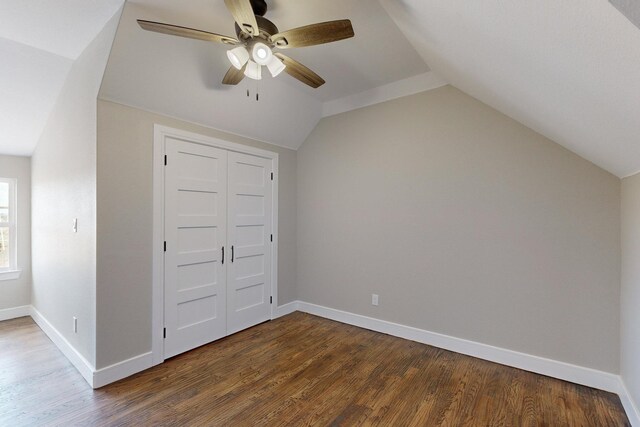 interior space with ceiling fan, baseboards, lofted ceiling, and wood finished floors