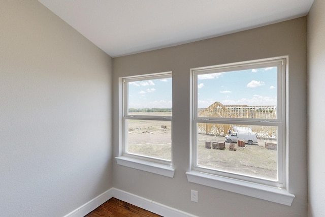 empty room featuring dark wood-style floors and baseboards