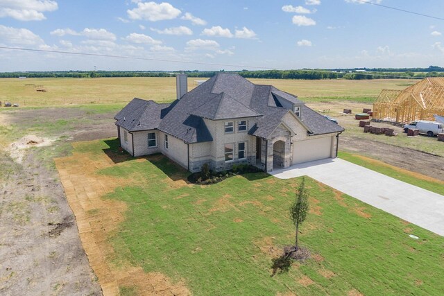 view of front of home with a garage and a rural view