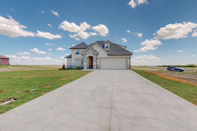 french country style house featuring a front yard, a rural view, and a garage