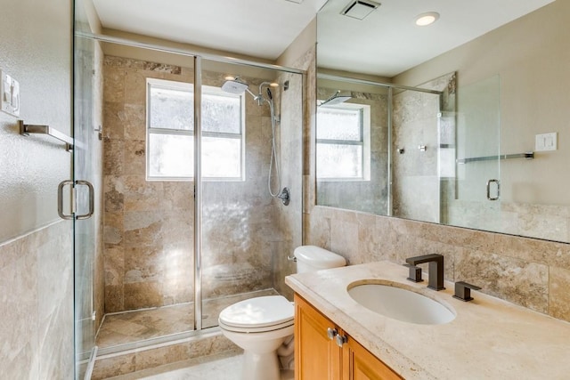 bathroom featuring vanity, toilet, and a shower with door