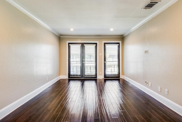 empty room featuring french doors, dark hardwood / wood-style flooring, and crown molding