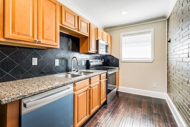 kitchen featuring light stone countertops, dark hardwood / wood-style flooring, ornamental molding, stainless steel appliances, and sink