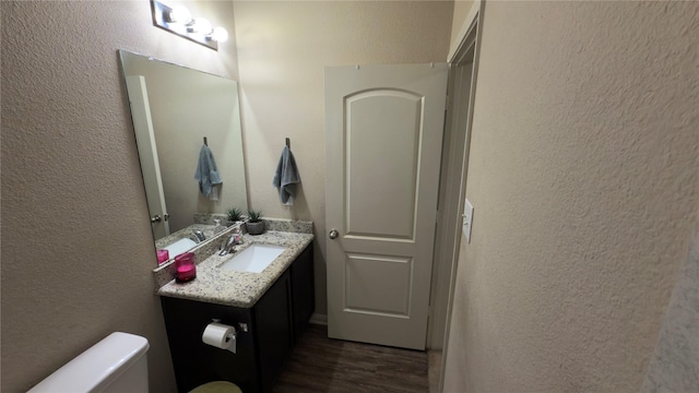 bathroom featuring vanity, wood-type flooring, and toilet