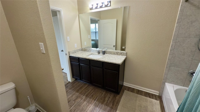 full bathroom featuring vanity, hardwood / wood-style floors, washtub / shower combination, and toilet