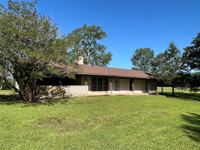 back of house featuring a lawn