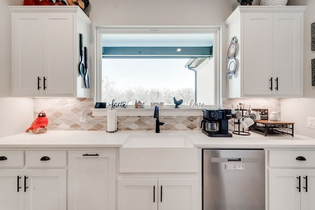 kitchen featuring white cabinets, tasteful backsplash, stainless steel dishwasher, and sink