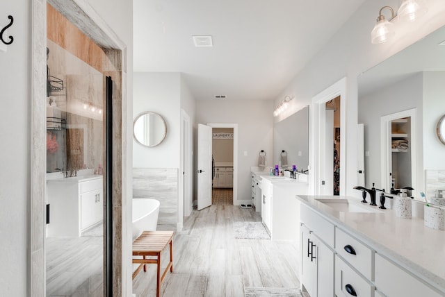 bathroom with hardwood / wood-style floors, vanity, tile walls, and shower with separate bathtub