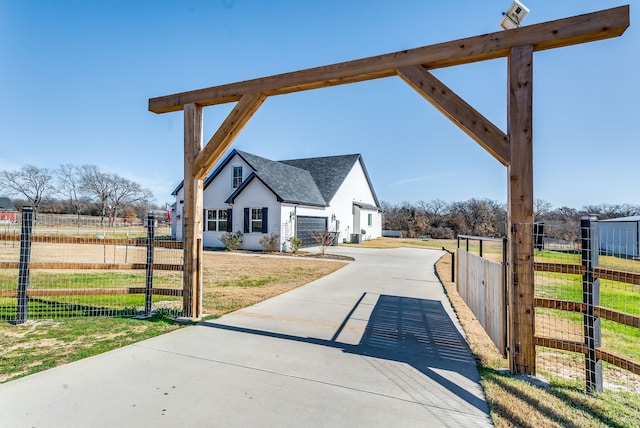 view of community with a garage, driveway, fence, and a gate