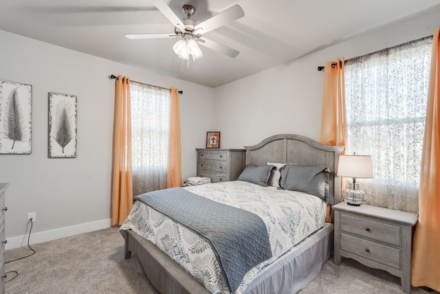 carpeted bedroom featuring ceiling fan and multiple windows