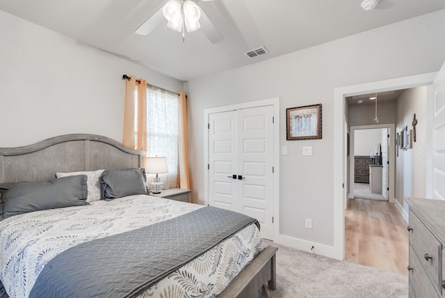 bedroom featuring a closet, ceiling fan, and light colored carpet