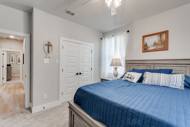 bedroom with ceiling fan, light carpet, and a closet