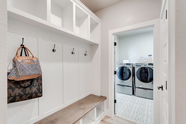 mudroom with light wood-type flooring and washing machine and dryer